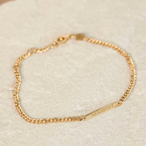 The Darcy Bracelet featuring a curb chain and engraved bar with surname