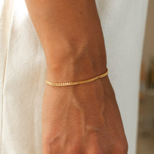 Model wearing a gold bracelet with custom engraving on the bar