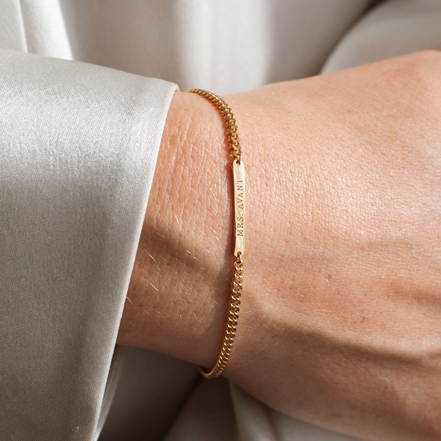 Gold custom engraving on a bar bracelet with curb chain