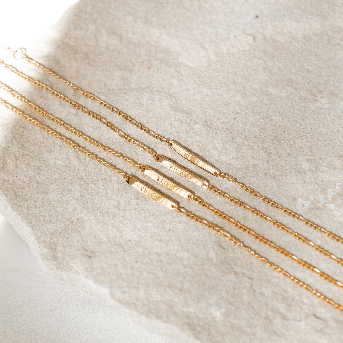 Examples of custom engravings on the Dayne Bracelet, featuring names, initials, roman numerals, and dates