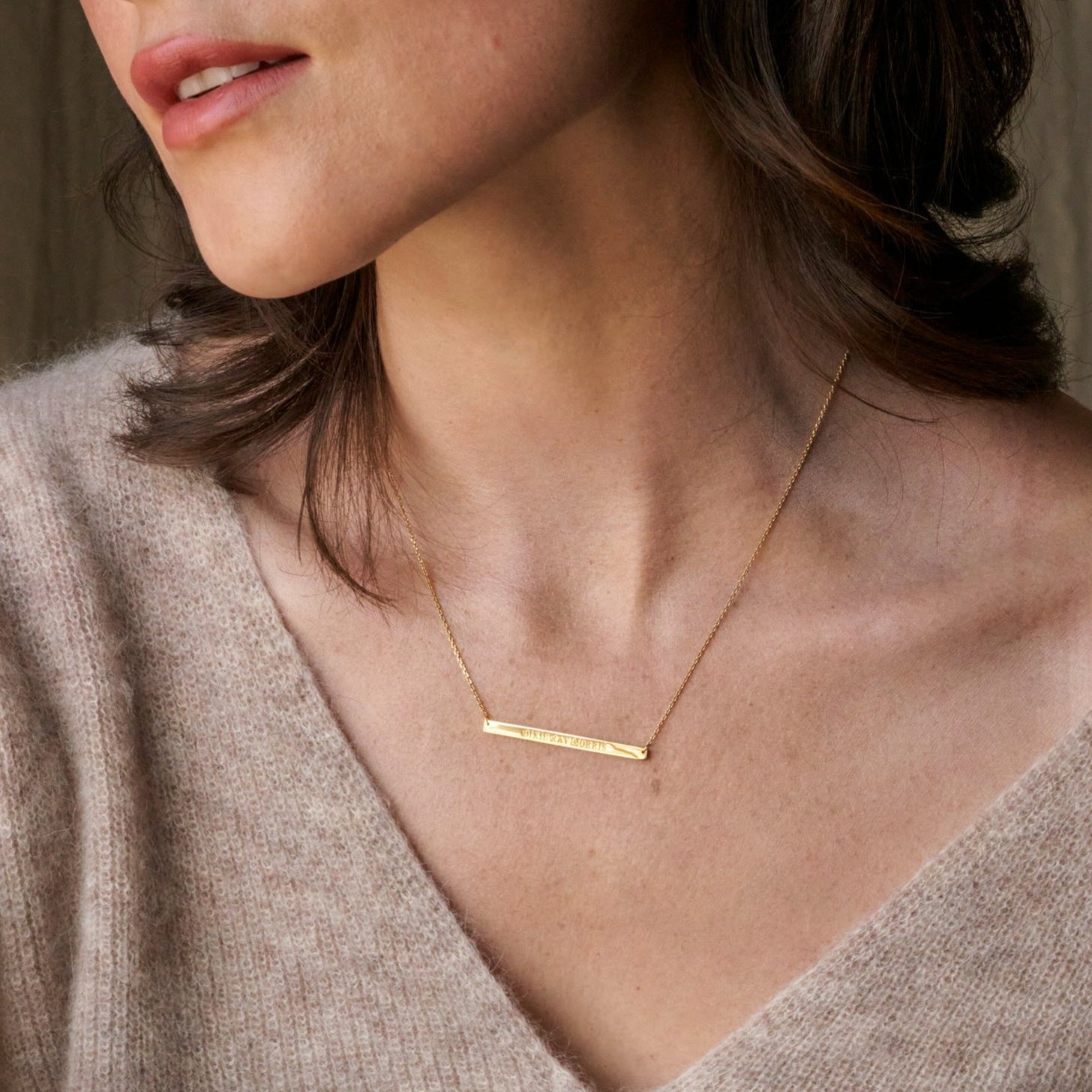 Model wears a dainty bar nameplate necklace with personalized names, messages, and coordinates
