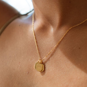 Custom engraved letter in a modern font on our Emma Dog Tag Pendant Necklace in gold, with 3 tags layered on one chain