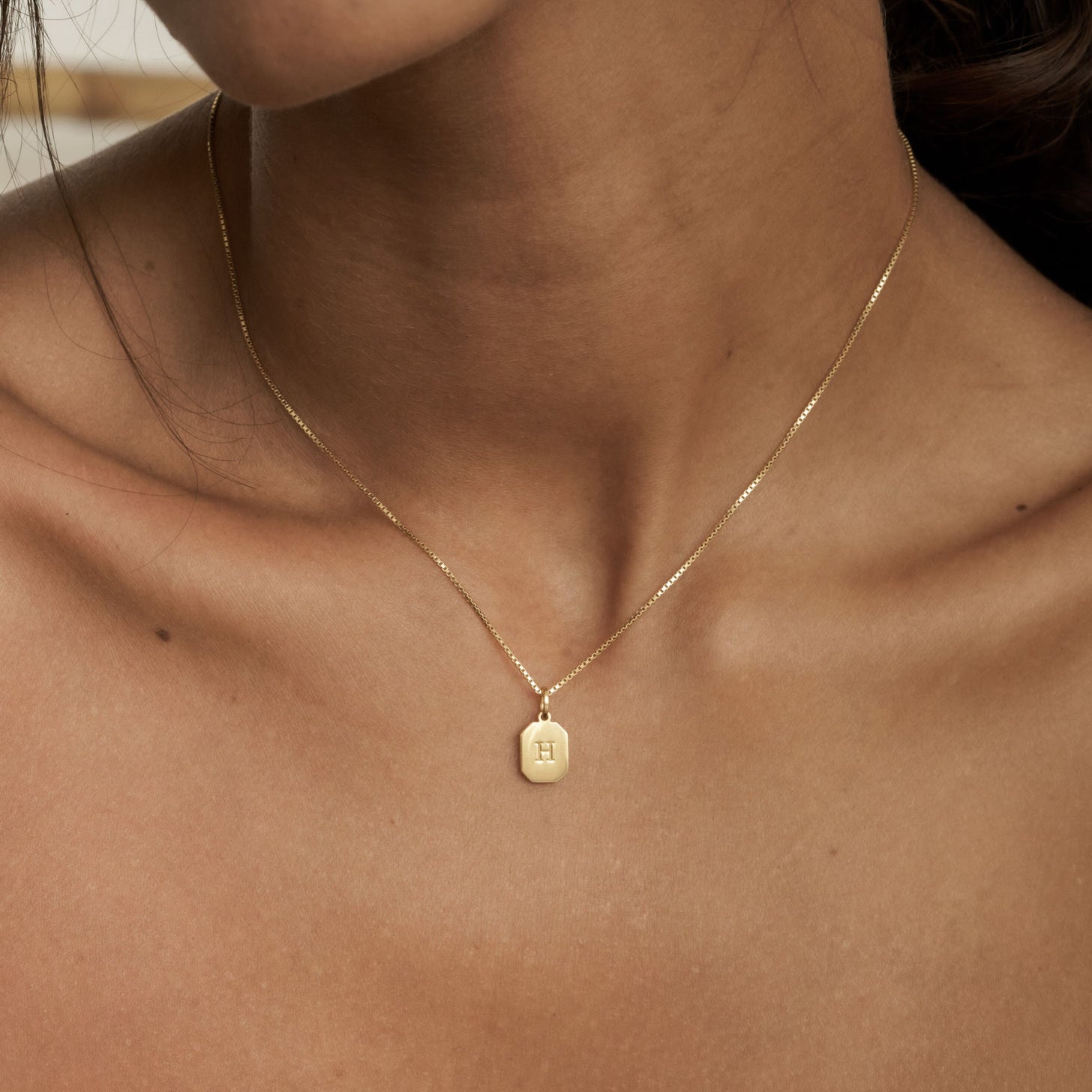 Box chain necklace with a small dog tag pendant with front and back custom initial engraving