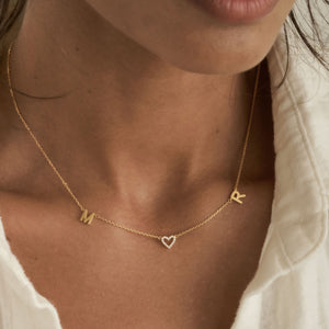 Dainty custom initials and a pave heart on a simple necklace