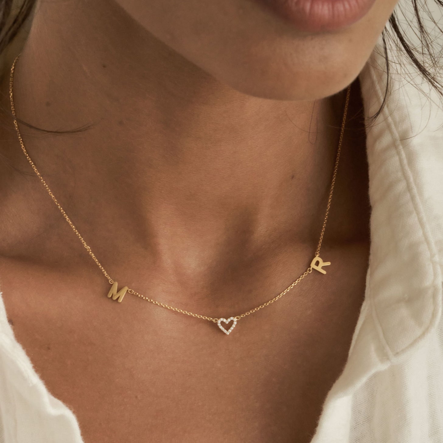 Dainty custom initials and a pave heart on a simple necklace