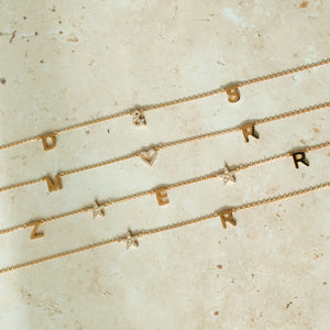 Examples of the Luna Initials Necklace with cubic zirconia stone hearts and stars