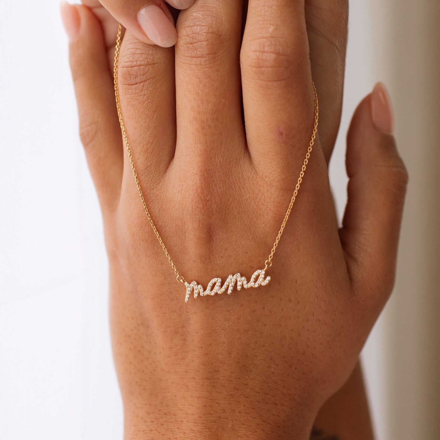 Necklace for mom with cubic zirconia stones and a handwritten script font on a gold chain
