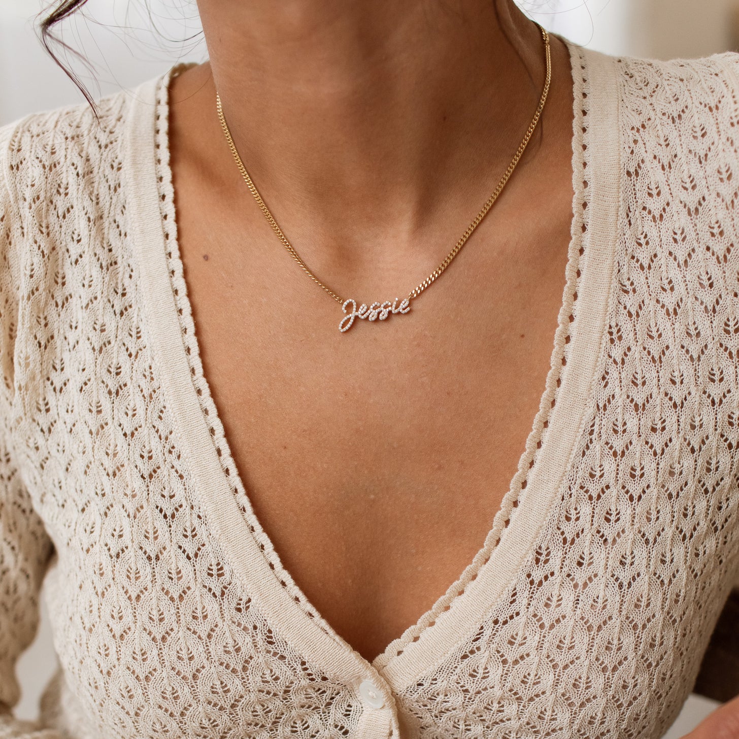 Model wearing a gold Naia Pave Name Necklace