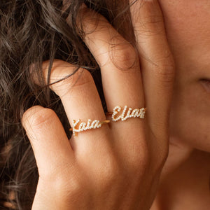 Model wearing pave script name rings with cubic zirconia stones