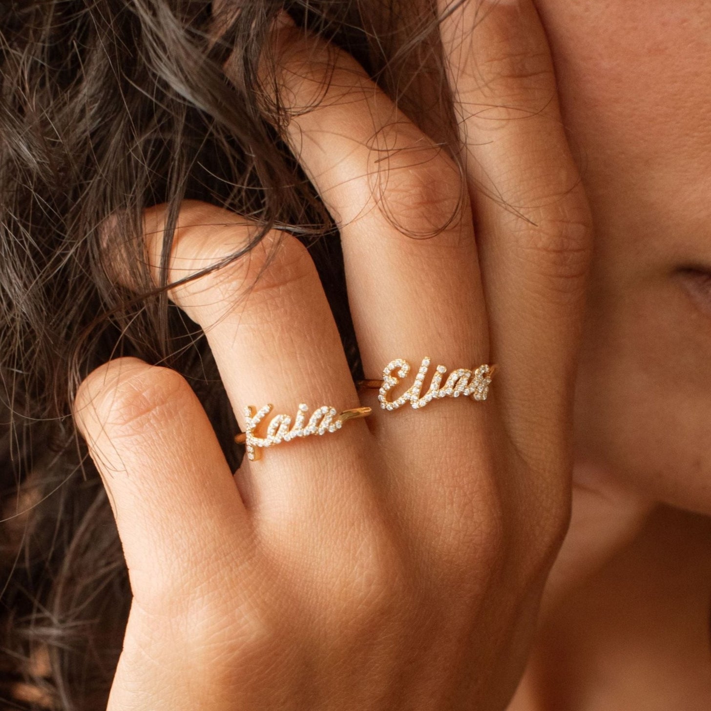 Model wearing pave script name rings with cubic zirconia stones