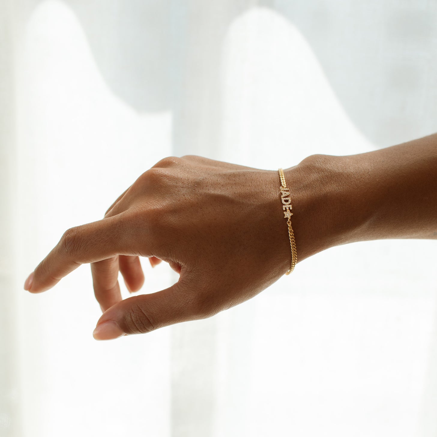 Model wearing a shimmering name bracelet, a perfect gift for her