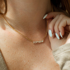 Model wearing shimmering pave name necklace with curb chain