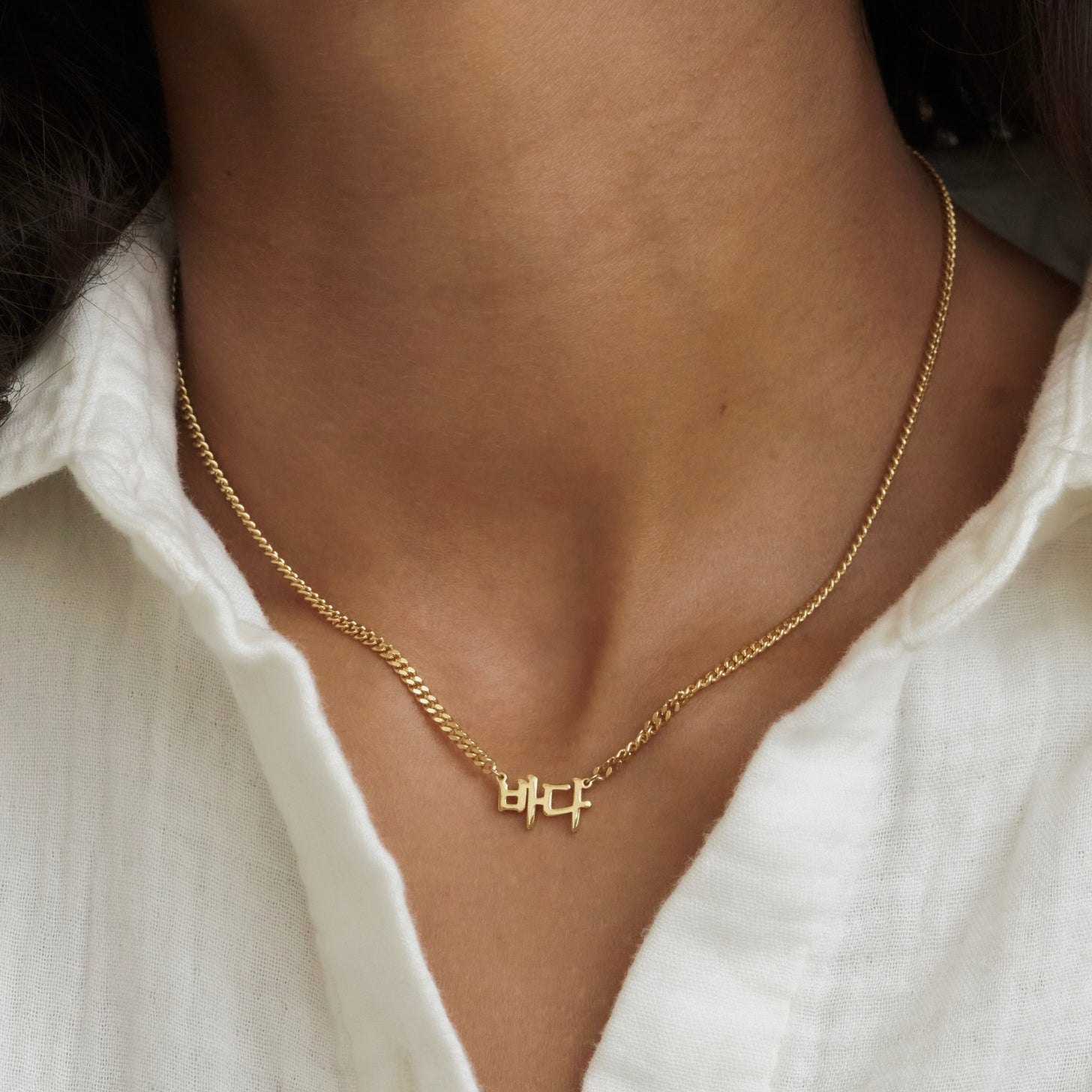 Custom name necklace with Korean characters and a gold curb chain