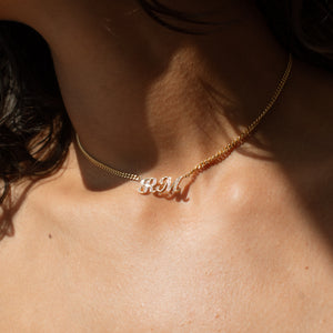 Nameplate necklace in gold, silver, and rose gold, and featuring diamond letters on a bold curb chain