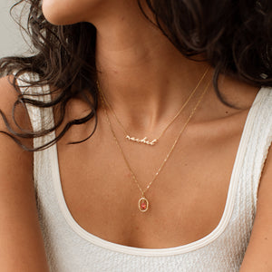 Personalized script name necklace in handwritten font, layered with a garnet birthstone necklace