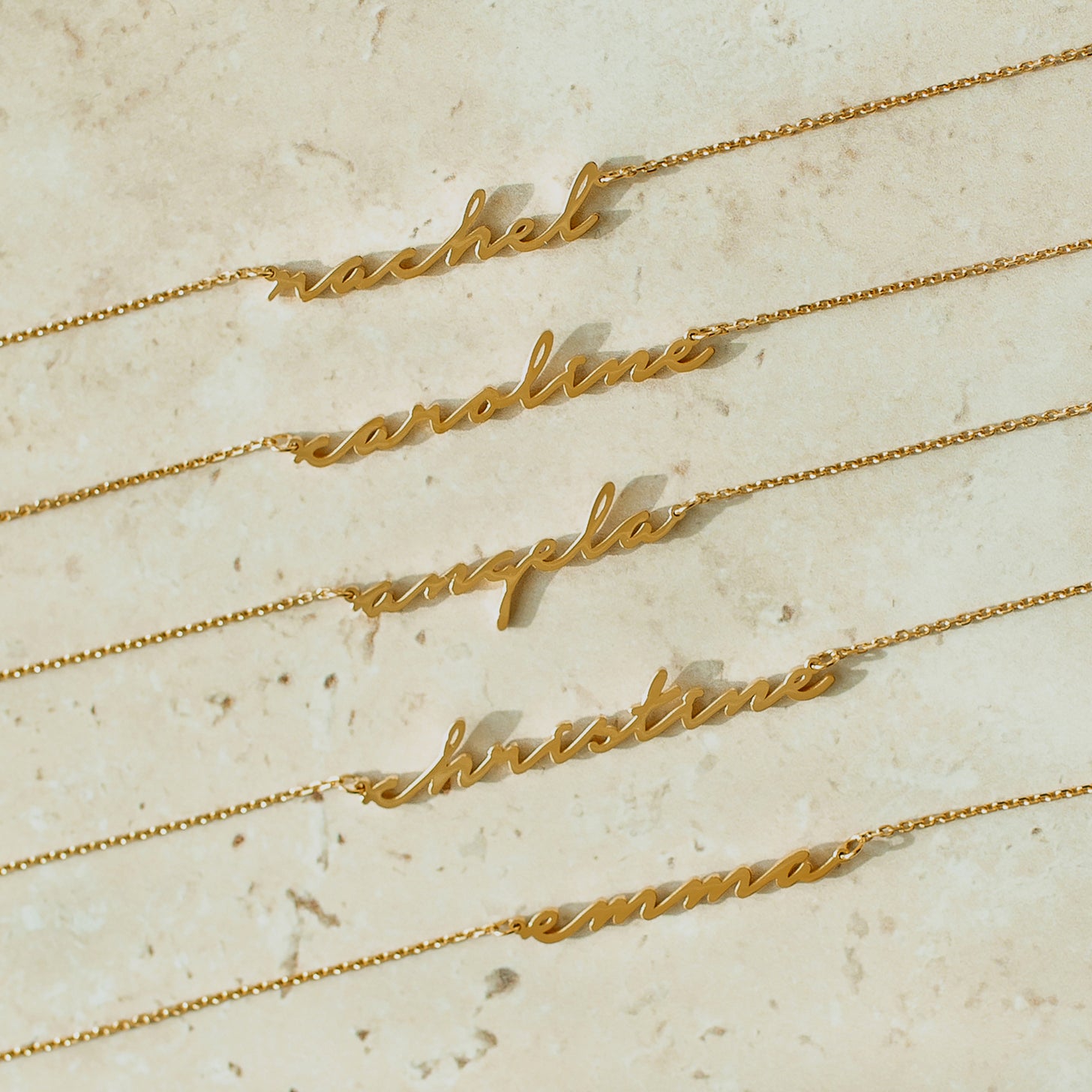 Gold examples of custom name necklace in cursive script font