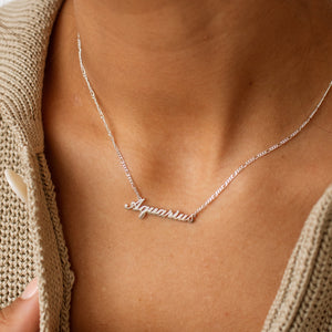 Model wears a silver Aquarius star sign necklace on a dainty chain