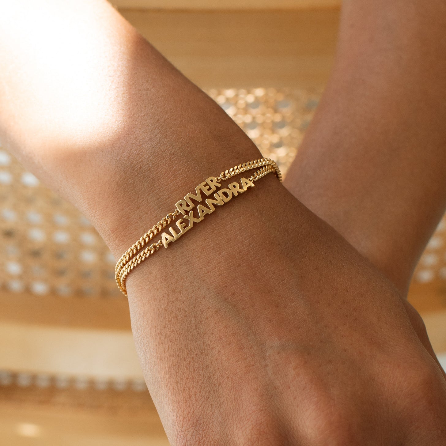 Model wearing custom name bracelets with curb chain