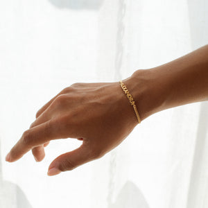 Model wearing a modern name bracelet with bold curb chain