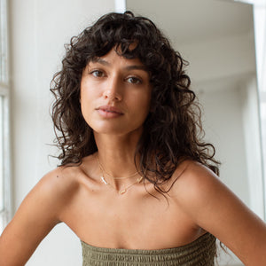 Model wearing gold Nelsey Multiple Name Necklace