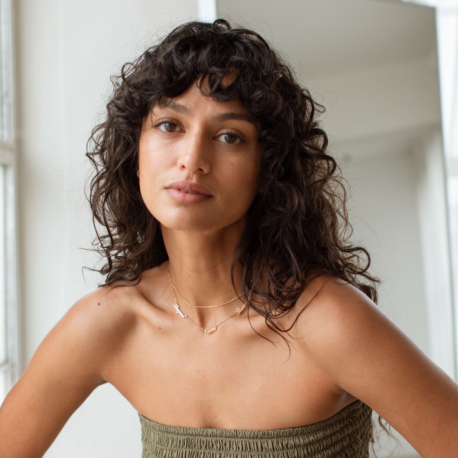 Model wearing gold Nelsey Multiple Name Necklace