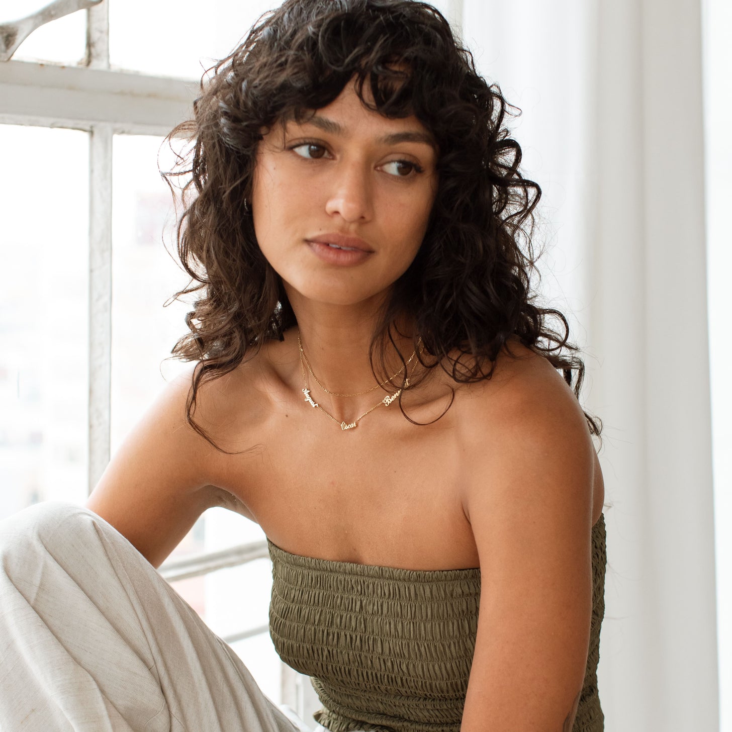 Model wearing 3-name gold Nelsey Necklace with multiple names