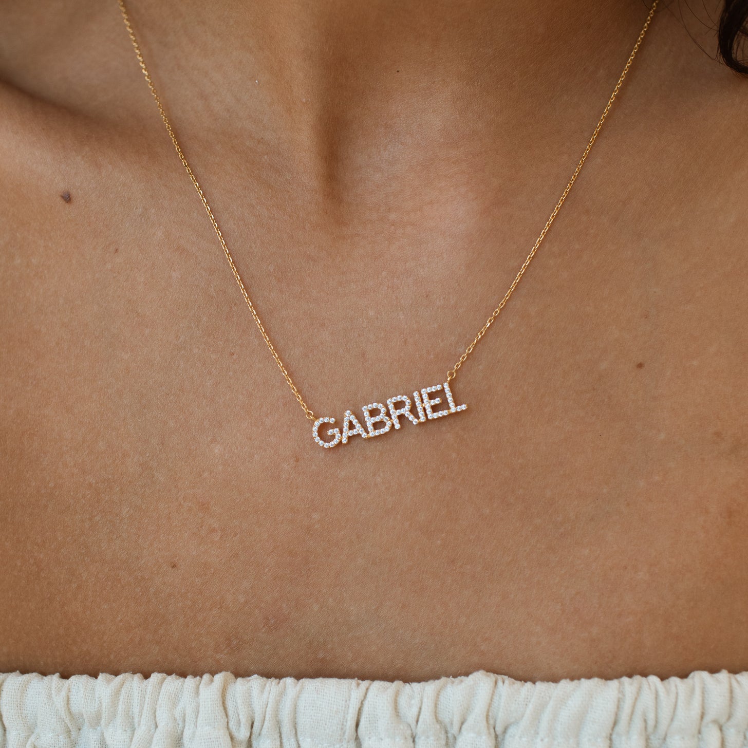 Model wearing gold pave Nina Name Necklace
