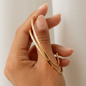 Engraved coordinates on the gold Rebecca Cuff Bracelet by Grace Personalized