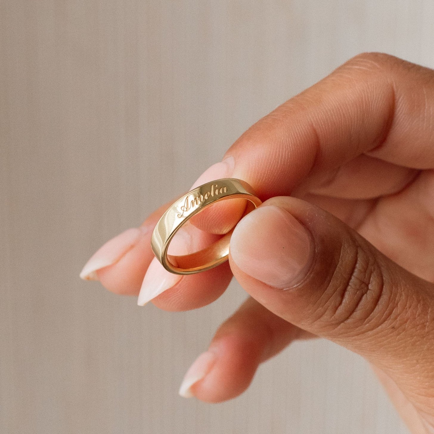 Gold band ring with custom outer engraving in elegant font