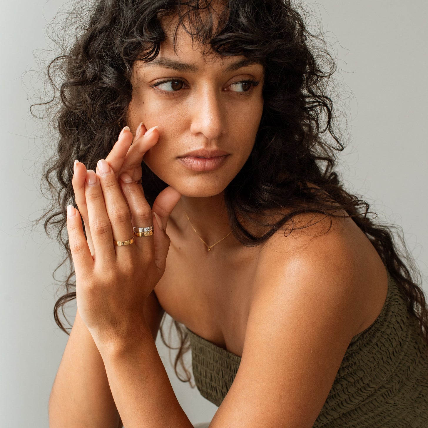 Model wears gold and silver Rihana Rings with custom engraving of names and messages