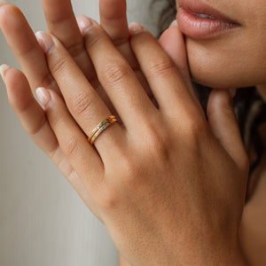 Model wears gold band rings with custom engraving and birthstones